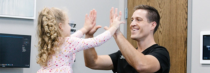 Chiropractor Overland Park KS Joshua Whitmore High Fiving Pediatric Patient